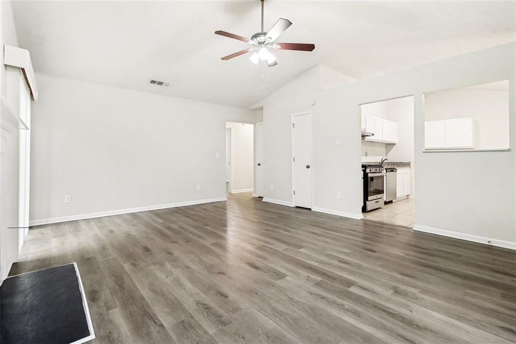 5474 Panola Downs Road Lithonia, GA 30058 - Photo 5 of 27 a view of empty room with wooden floor and fan