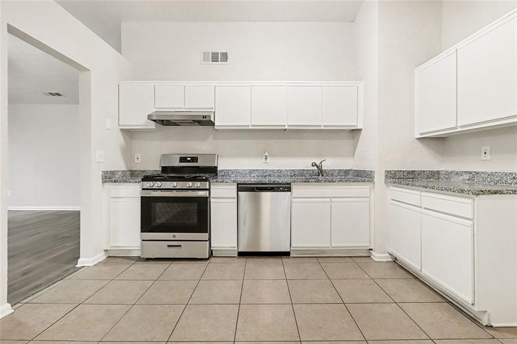 5474 Panola Downs Road Lithonia, GA 30058 - Photo 9 of 27 a kitchen with granite countertop white cabinets and appliances