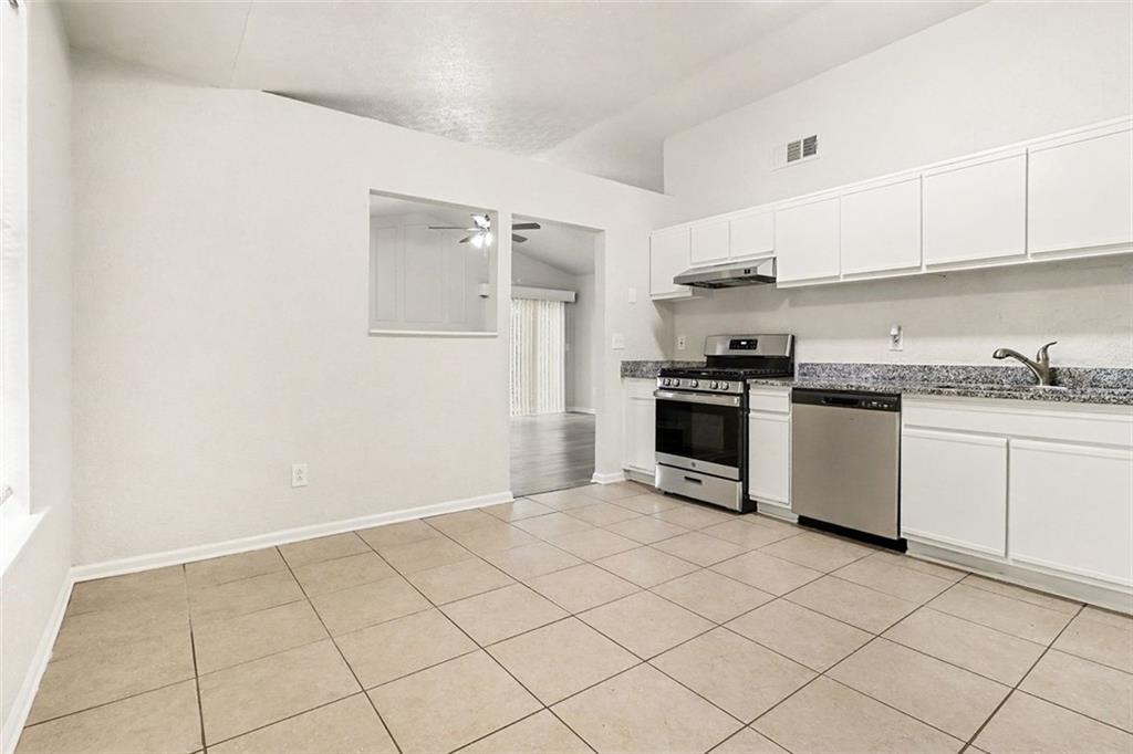 5474 Panola Downs Road Lithonia, GA 30058 - Photo 10 of 27 a kitchen with granite countertop white cabinets and stainless steel appliances