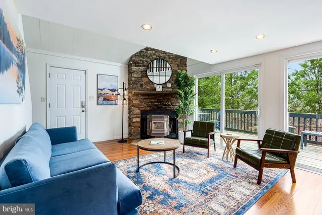 a living room with furniture a fireplace and a large window