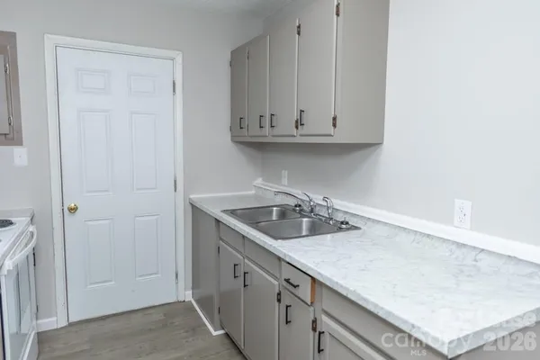 a kitchen with granite countertop a sink and cabinets