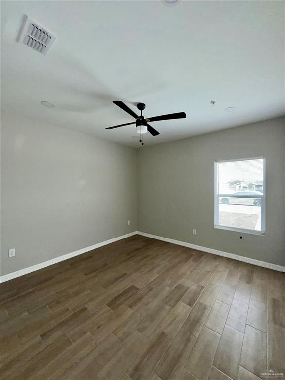 720 Ragland Road, Unit 2 Mission, TX 78572 - Photo 6 of 8 wooden floor in an empty room with a window