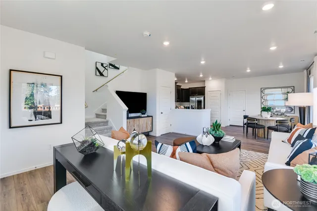 a living room with furniture a flat screen tv and a large window