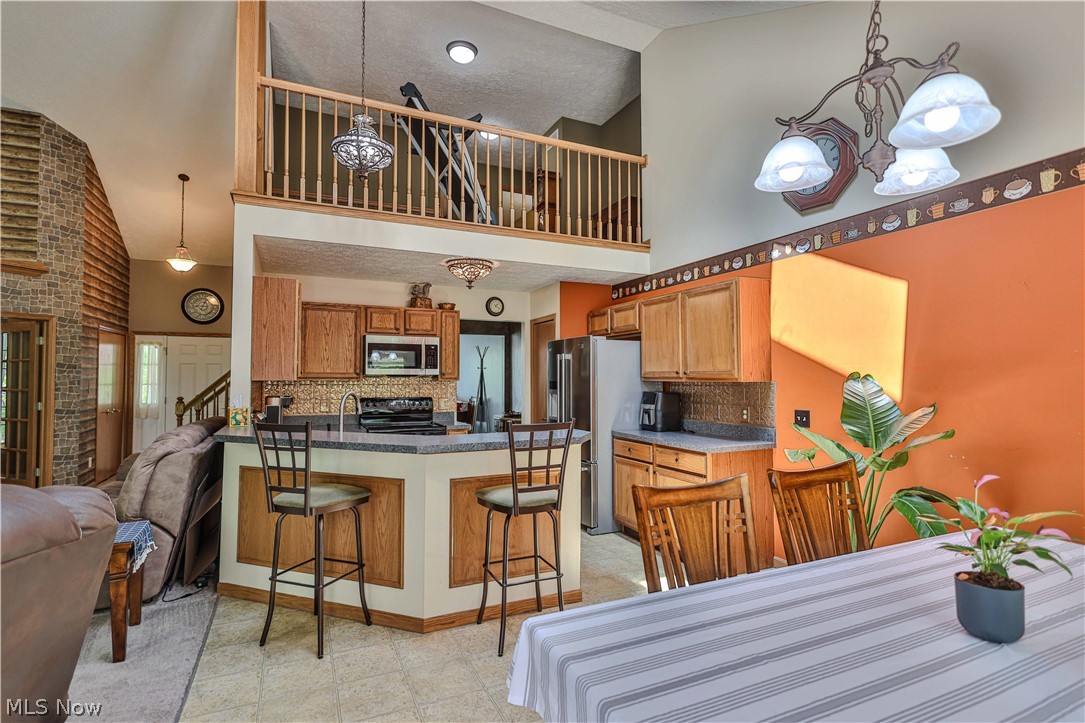 11154 Johnsford Road Southwest Beach City, OH 44608 - Photo 26 of 50 Kitchen featuring wood cabinetry, stainless steel appliances, and a breakfast bar with seating