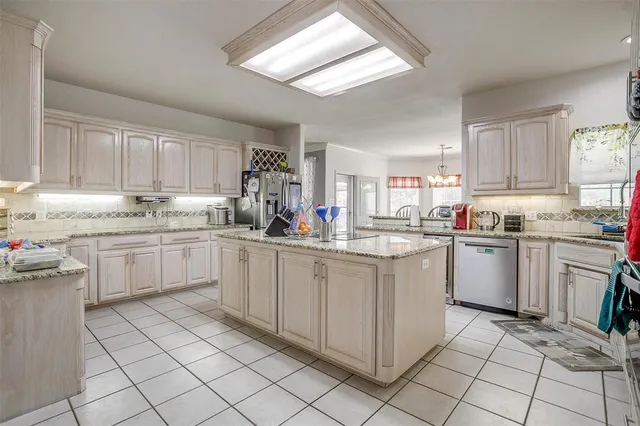 a kitchen with a sink window and cabinets