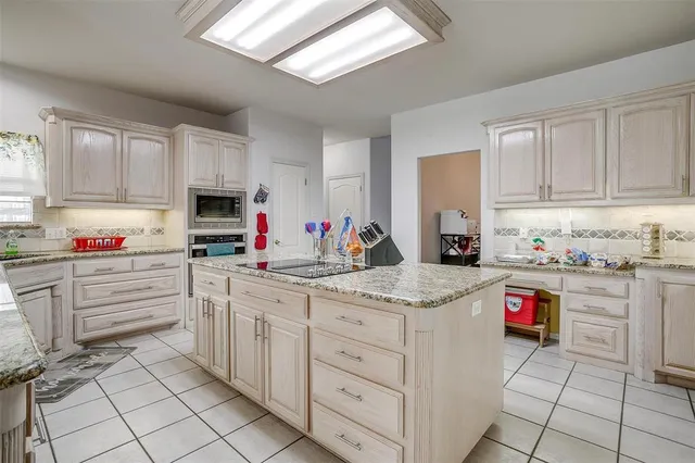 a kitchen with granite countertop a sink stainless steel appliances and cabinets