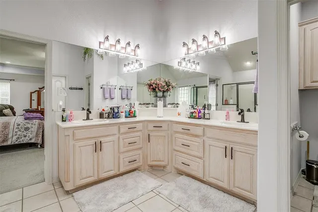 a spacious en suite bathroom with a double vanity sink and a mirror