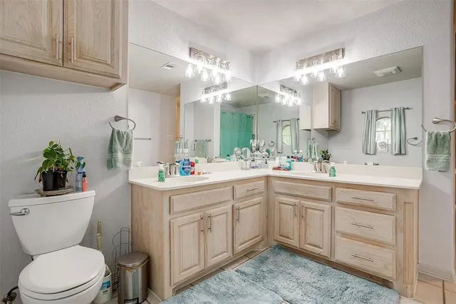 a spacious bathroom with a double vanity sink a mirror and a shower