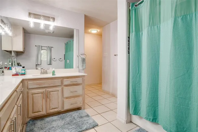 a bed sitting in a spacious bedroom next to a window