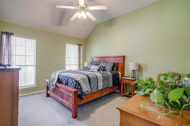 a bedroom with a bed a chair and a large window