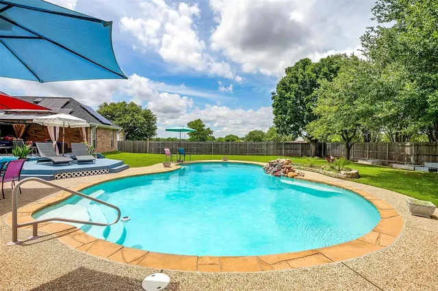 a swimming pool with outdoor seating and yard