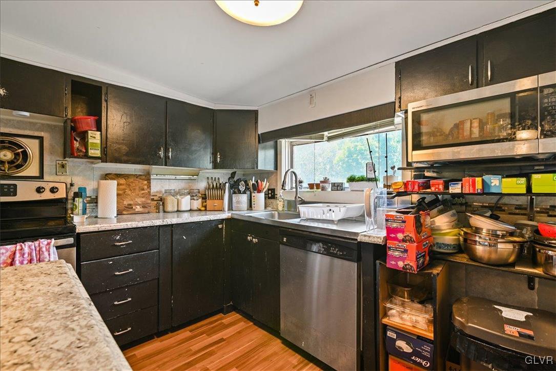 1324 Main Street Northampton, PA 18067 - Photo 20 of 49 a kitchen with stainless steel appliances granite countertop a sink and wooden cabinets