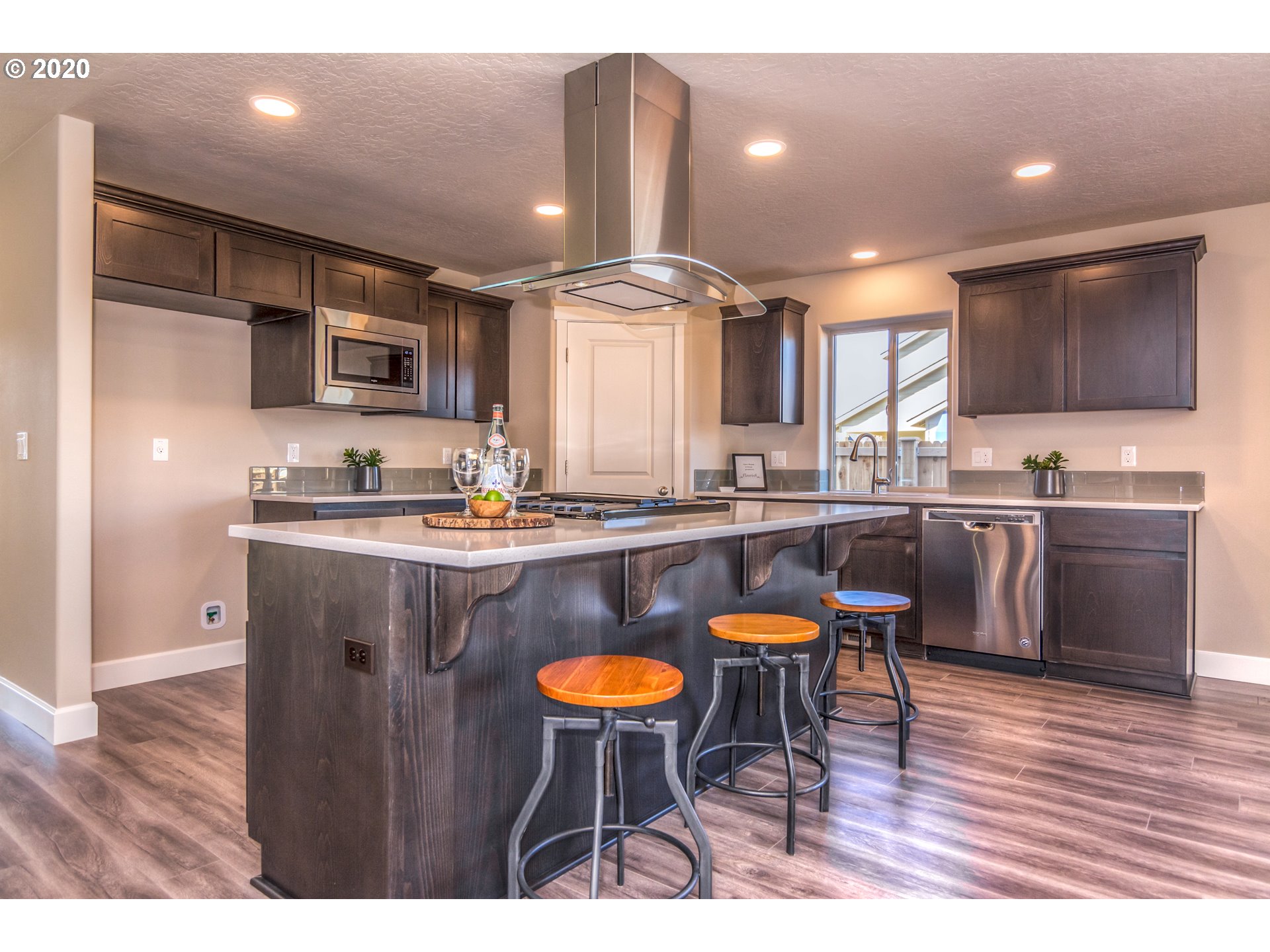 475 South 10th Street Monroe, OR 97456 - Photo 19 of 24 a kitchen with stainless steel appliances granite countertop a sink a stove a kitchen island with chairs and wooden floor