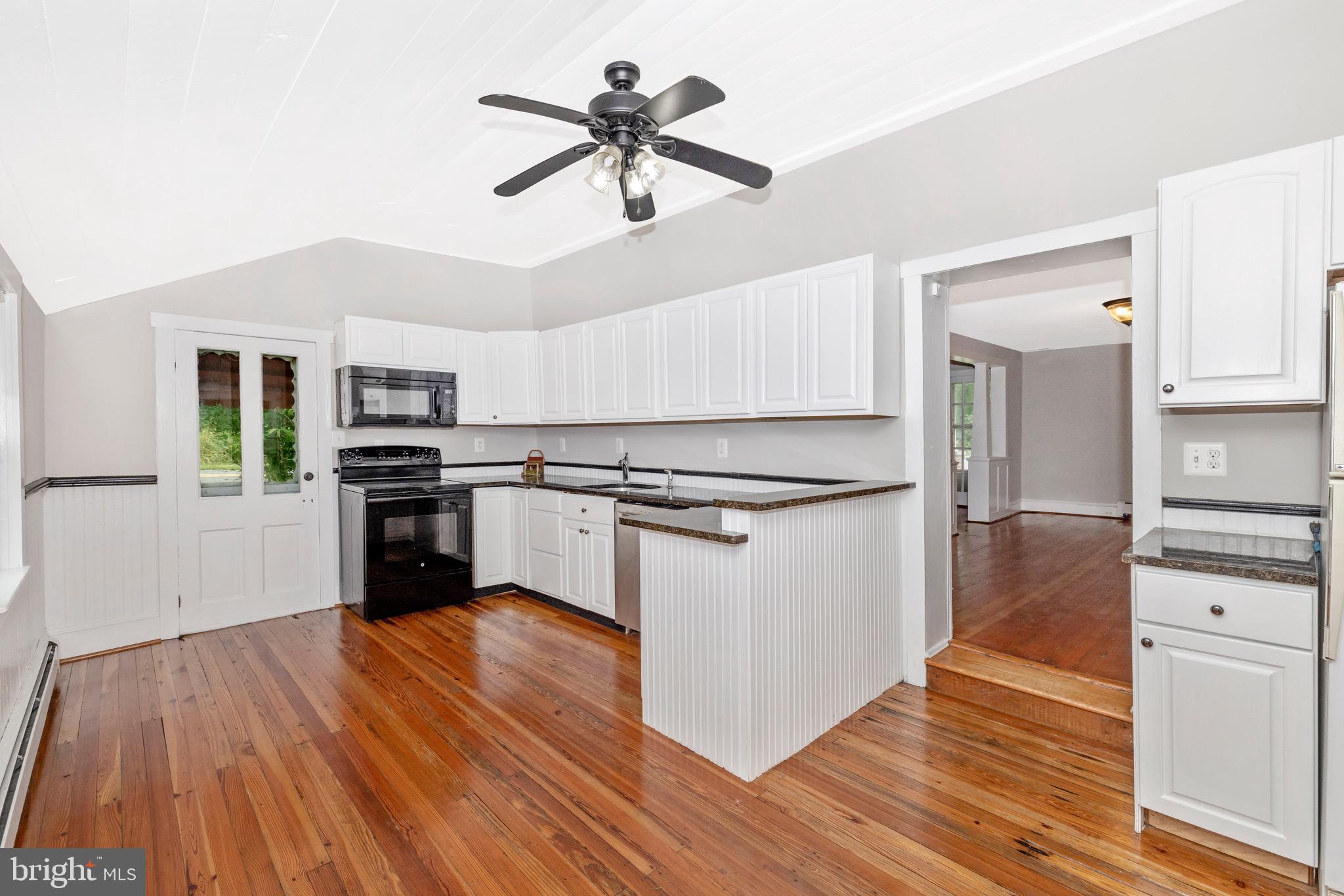 12261 Baugher Road Thurmont, MD 21788 - Photo 4 of 61 a kitchen with granite countertop a stove top oven and cabinets