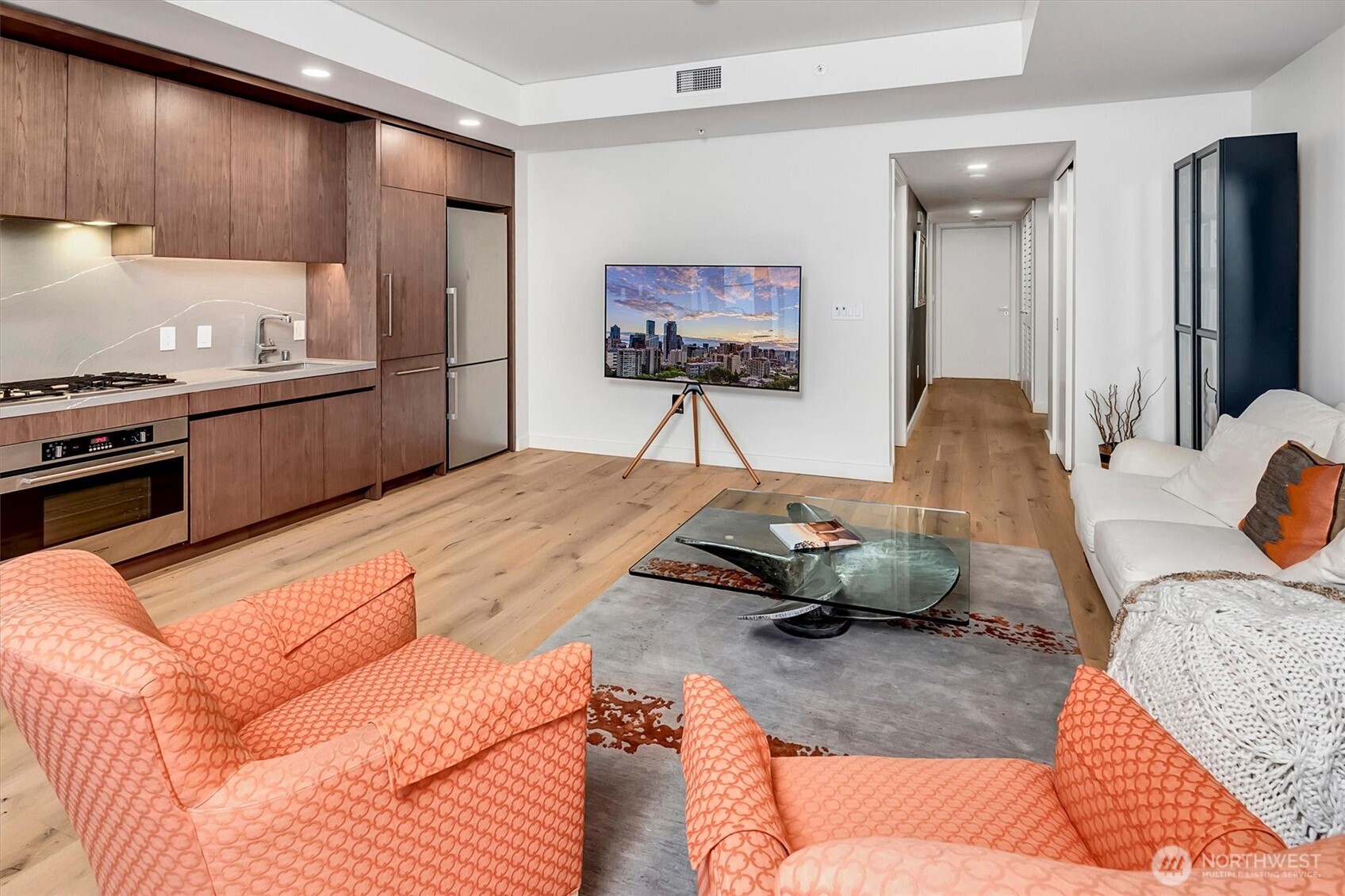 121 Stewart Street, Unit 504 Seattle, WA 98101 - Photo 7 of 27 a living room with furniture and kitchen view