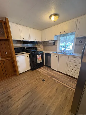 a living room with chairs and a chandelier