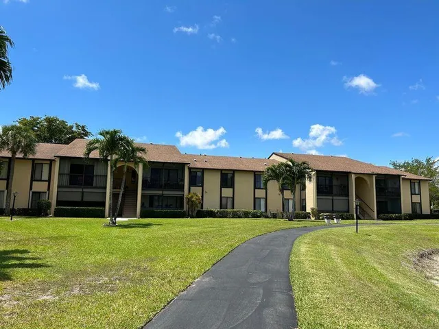 a view of a house next to a yard with palm trees