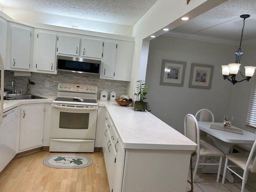825 Sky Pine Way, Unit C1 Greenacres, FL 33415 - Photo 9 of 18 a kitchen with a stove a sink and a refrigerator