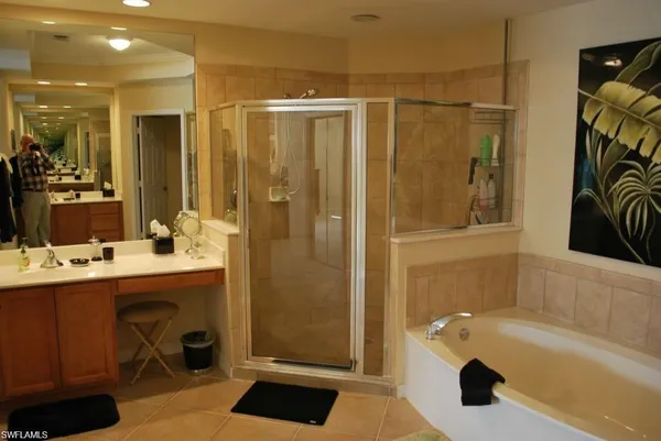 a bathroom with a tub a sink and a large mirror
