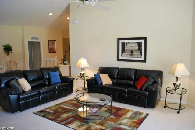 a living room with furniture a rug and a lamp