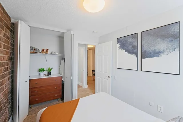 a bedroom with a bed and a painting on the wall