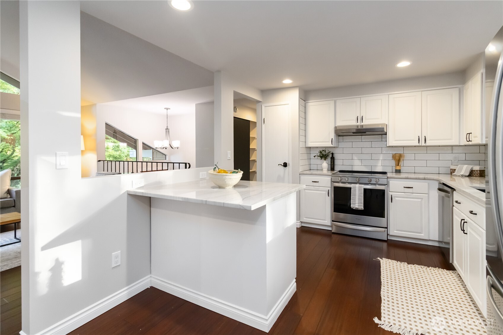 10621 Northeast 147th Street Bothell, WA 98011 - Photo 11 of 36 a kitchen with stainless steel appliances kitchen island wooden cabinets and granite counter tops