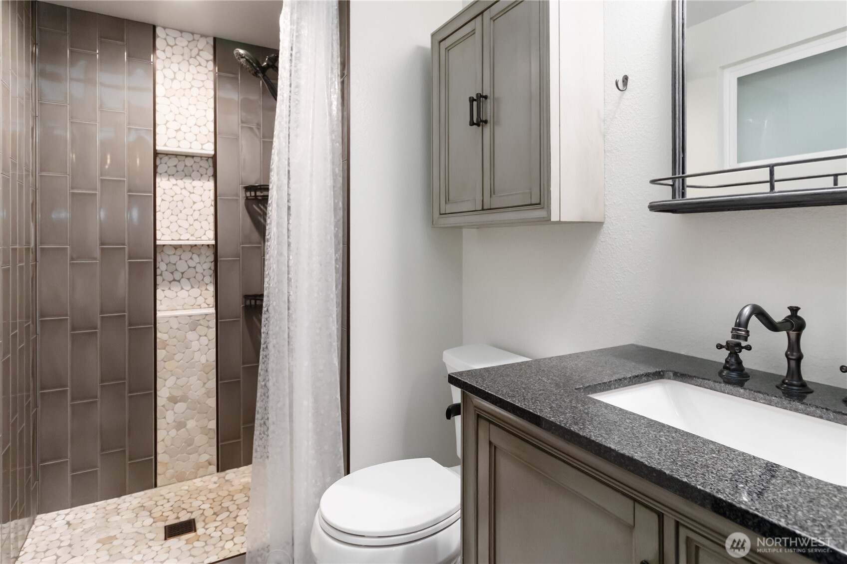 10621 Northeast 147th Street Bothell, WA 98011 - Photo 16 of 36 a bathroom with a granite countertop sink a toilet and shower