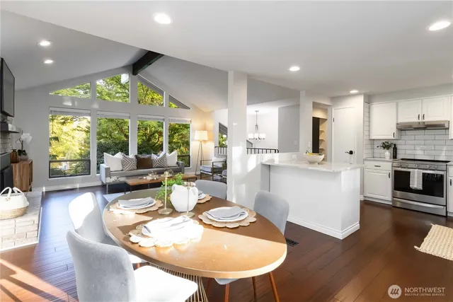 a kitchen with stainless steel appliances kitchen island granite countertop a dining table and chairs