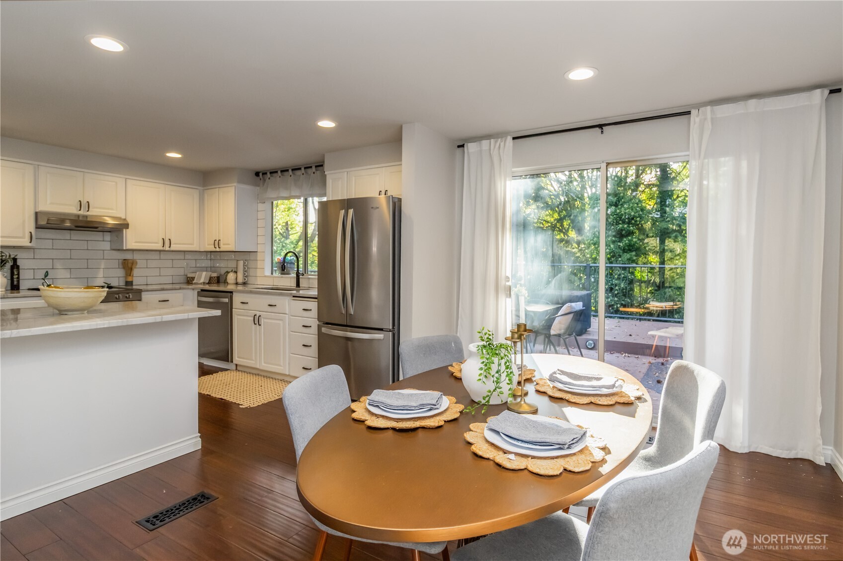 10621 Northeast 147th Street Bothell, WA 98011 - Photo 10 of 36 a kitchen with stainless steel appliances kitchen island granite countertop a dining table and chairs