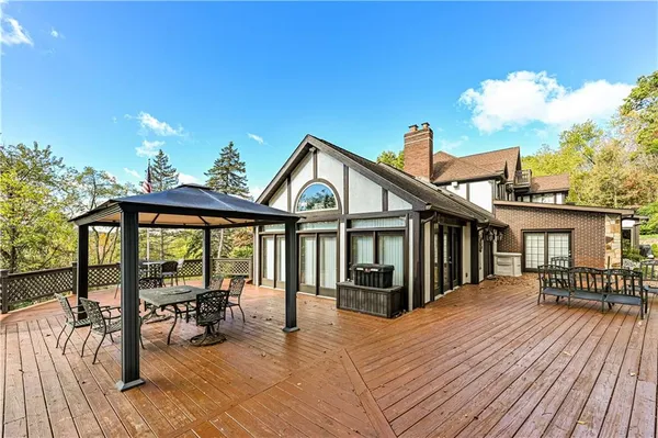 a view of a house with wooden deck and furniture