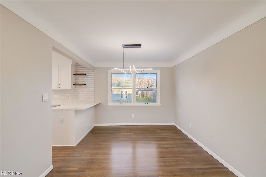 471 Snavely Road Cleveland, OH 44143 - Photo 12 of 35 Unfurnished room featuring dark wood-type flooring and a chandelier
