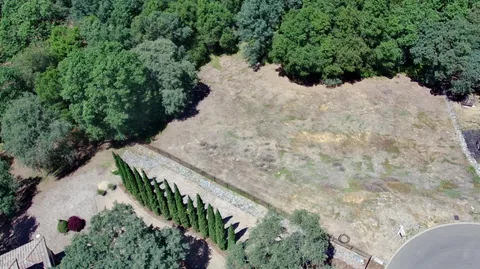 an aerial view of a house with a yard and lake view