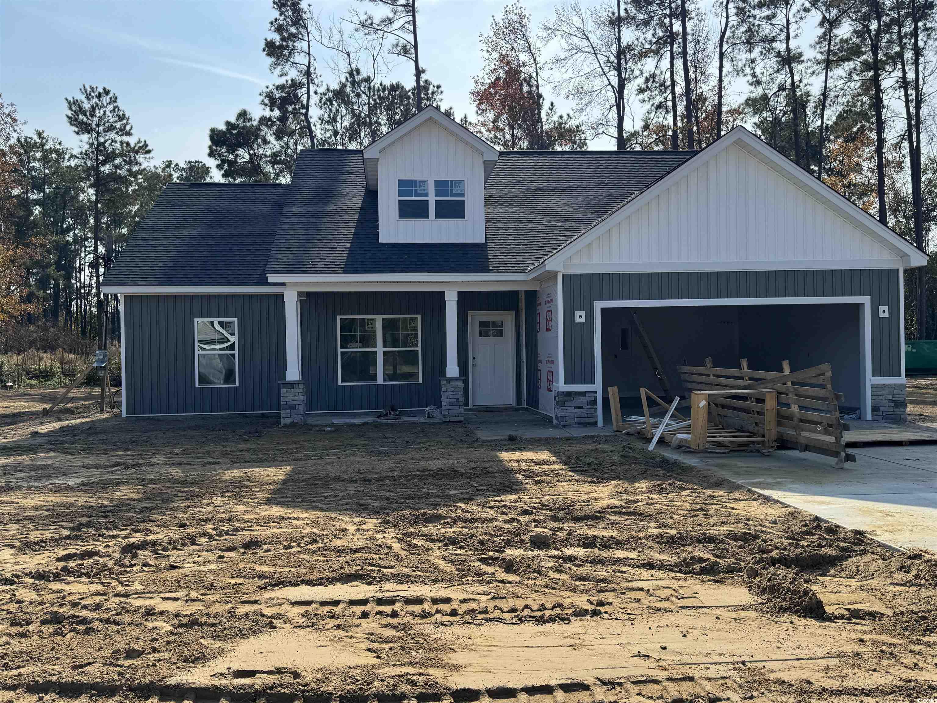 409 St John Road Galivants Ferry, SC 29544 - Photo 2 of 17 View of front of house with a porch, board and batten siding, a shingled roof, and an attached garage