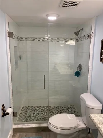 a bathroom with a toilet and a shower