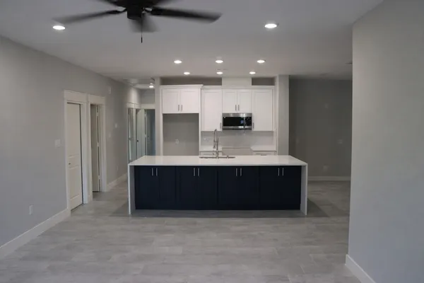 a large white kitchen with a stove and a refrigerator