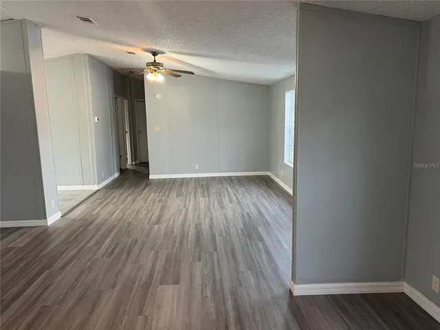 a view of a room with wooden floor and a ceiling fan