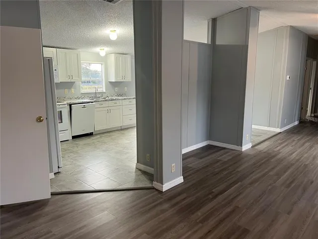 a view of a kitchen with wooden floor and electronic appliances