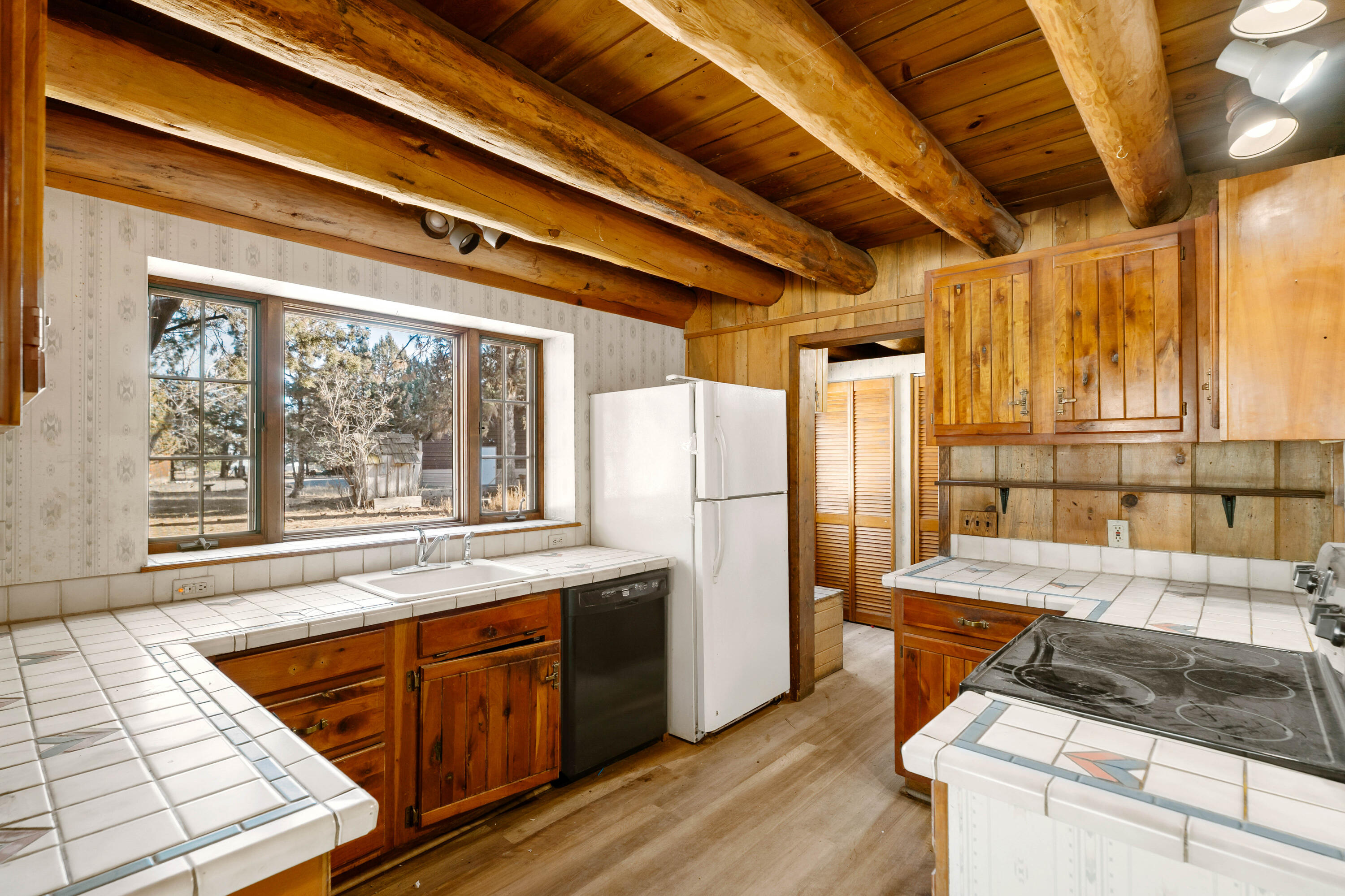 21910 Rickard Road Bend, OR 97702 - Photo 8 of 42 a kitchen with a stove a refrigerator and wooden cabinets