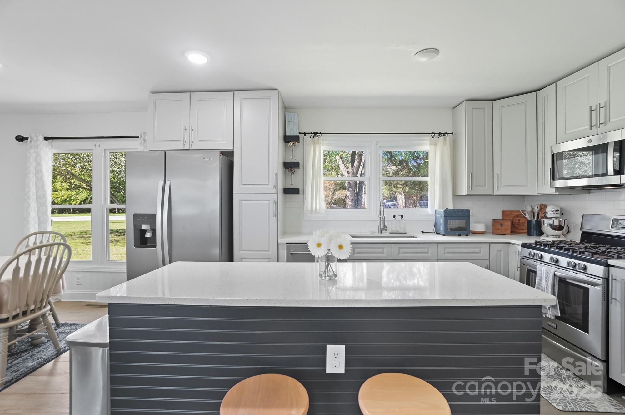 813 Bethlehem Road Kings Mountain, NC 28086 - Photo 10 of 39 a kitchen with stainless steel appliances granite countertop a stove a sink a refrigerator white cabinets and wooden floor