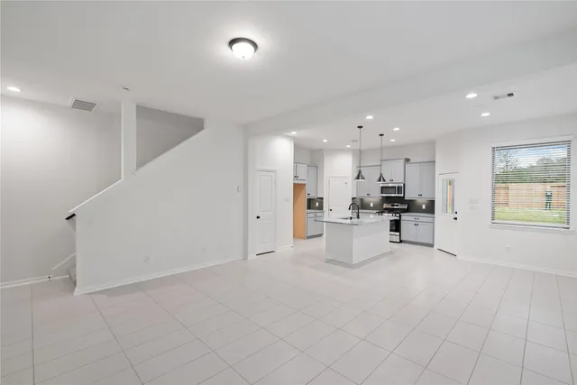 a view of kitchen with kitchen island white cabinets and refrigerator
