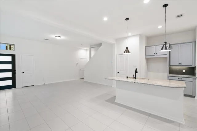a large white kitchen with a sink and dishwasher with white cabinets