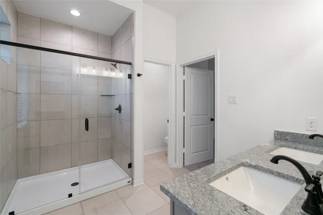 a bathroom with a granite countertop sink and shower