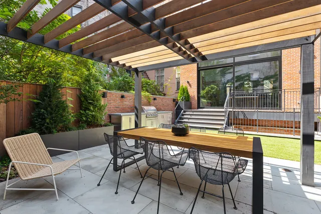 a roof deck with table and chairs and potted plants