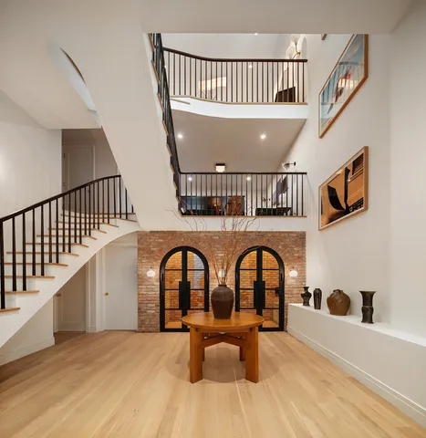 a view of staircase with lots of frames on wall and a window