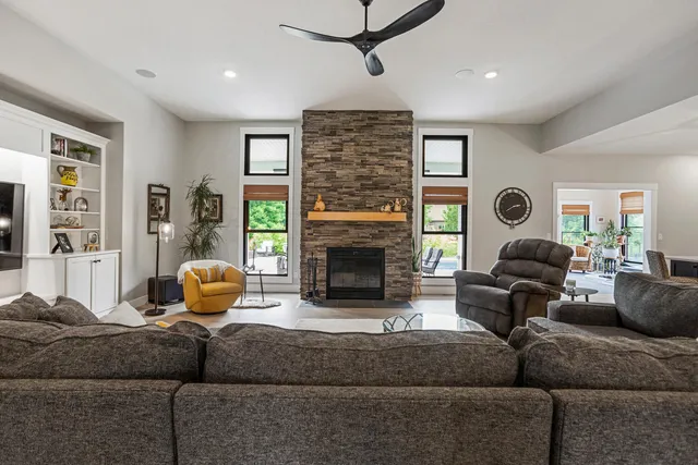 a living room with furniture kitchen view and a wooden floor