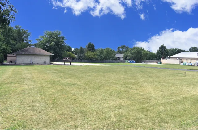 a view of a field with an trees in the background