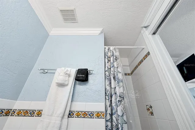 a bedroom with a bed and a lamp on dresser