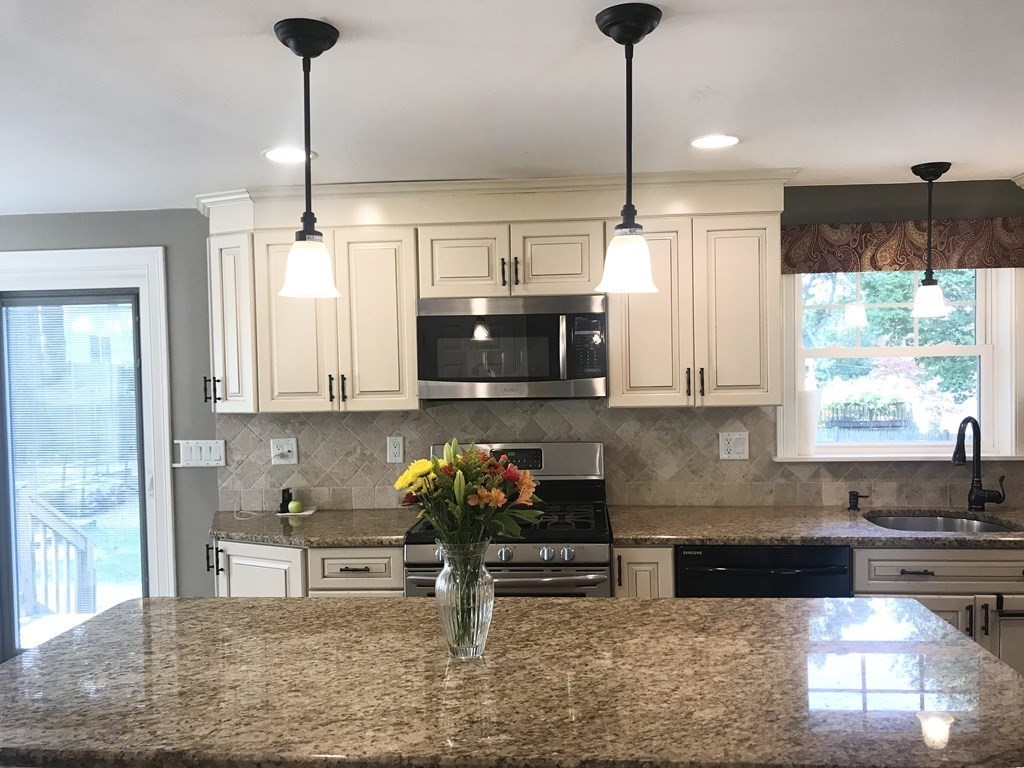11 Woodbury Road Billerica, MA 01821 - Photo 3 of 27 a kitchen with stainless steel appliances granite countertop a stove a sink and a microwave