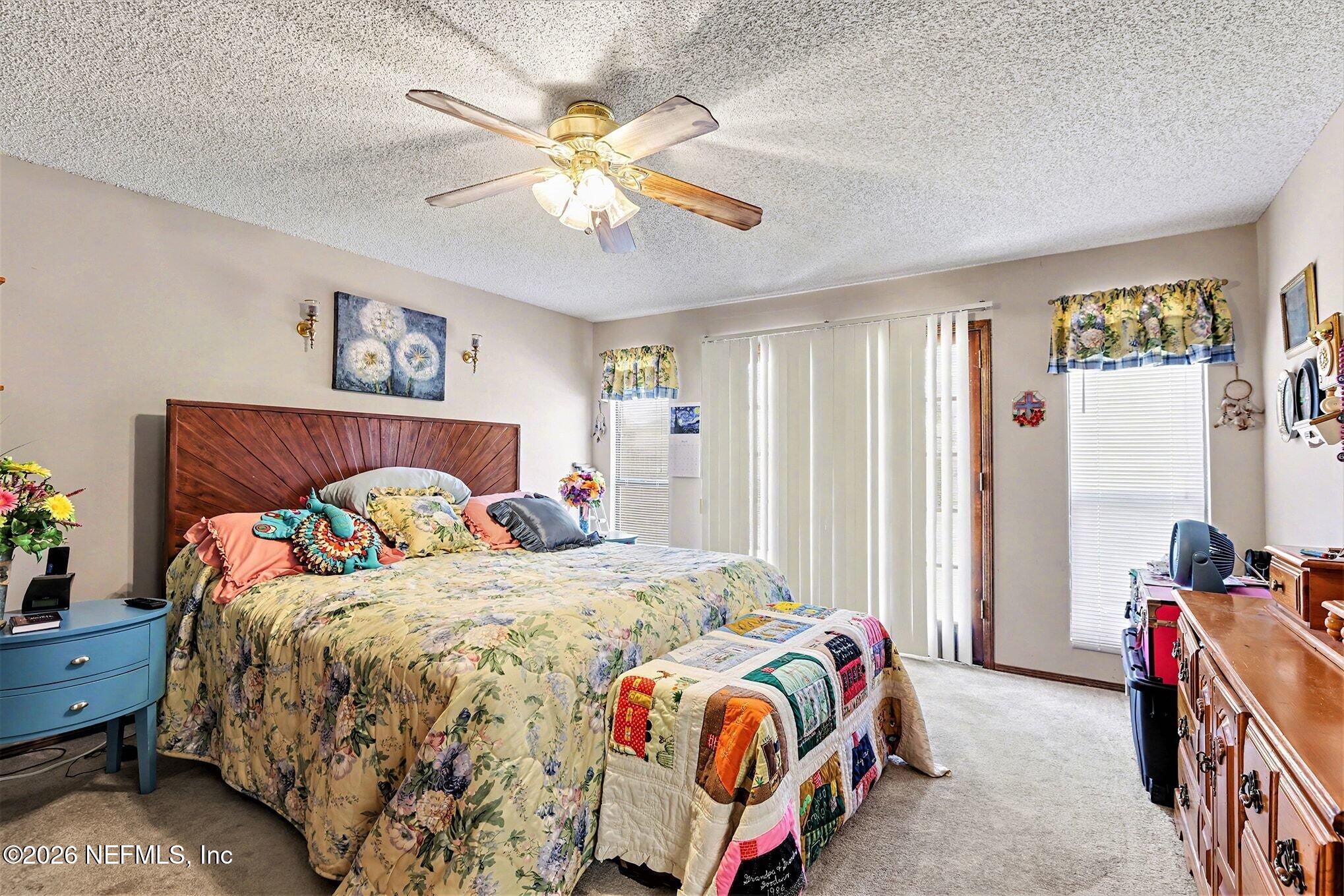 2551 Ridgecrest Avenue Orange Park, FL 32065 - Photo 12 of 28 a bedroom with a bed and a chandelier