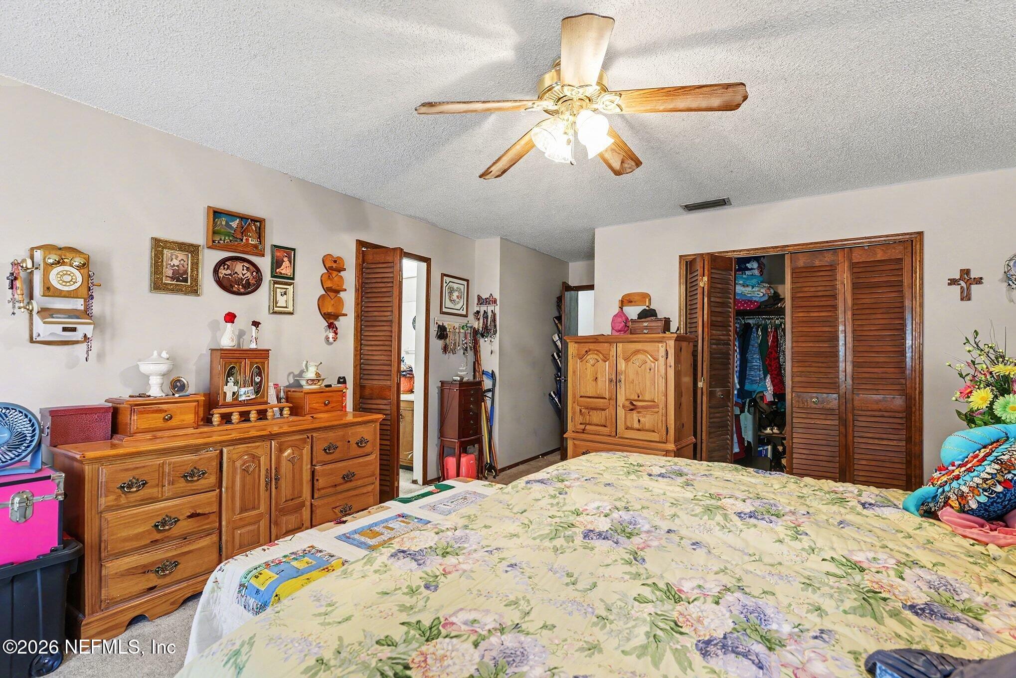 2551 Ridgecrest Avenue Orange Park, FL 32065 - Photo 13 of 28 a bedroom with a bed and a chandelier